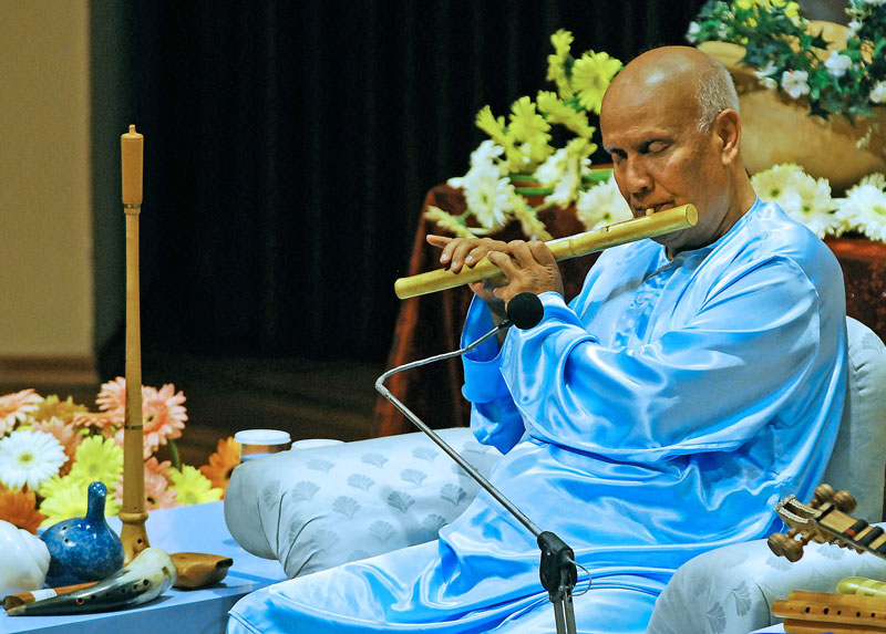 Sri Chinmoy playing the flute during a Peace Concert